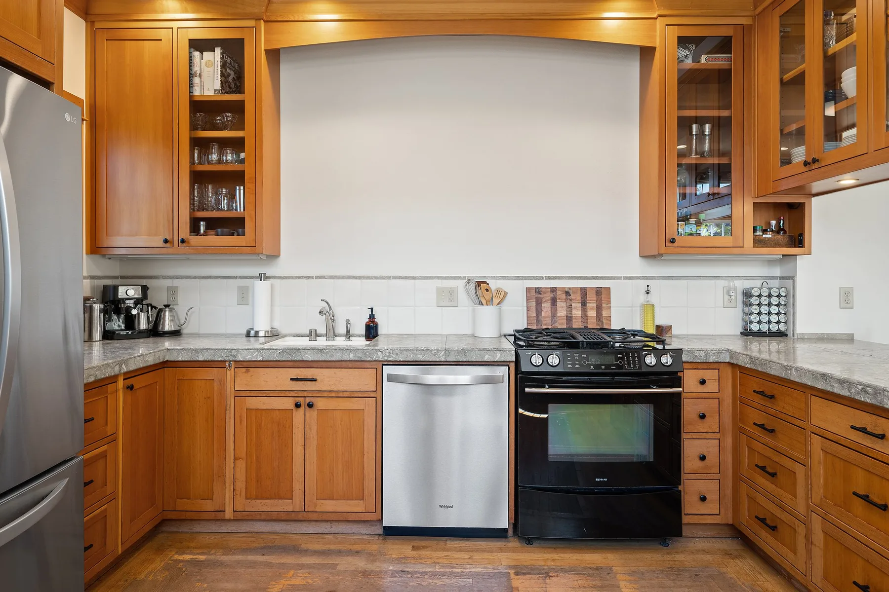 Una cocina con gabinetes de madera, una encimera y una estufa.
