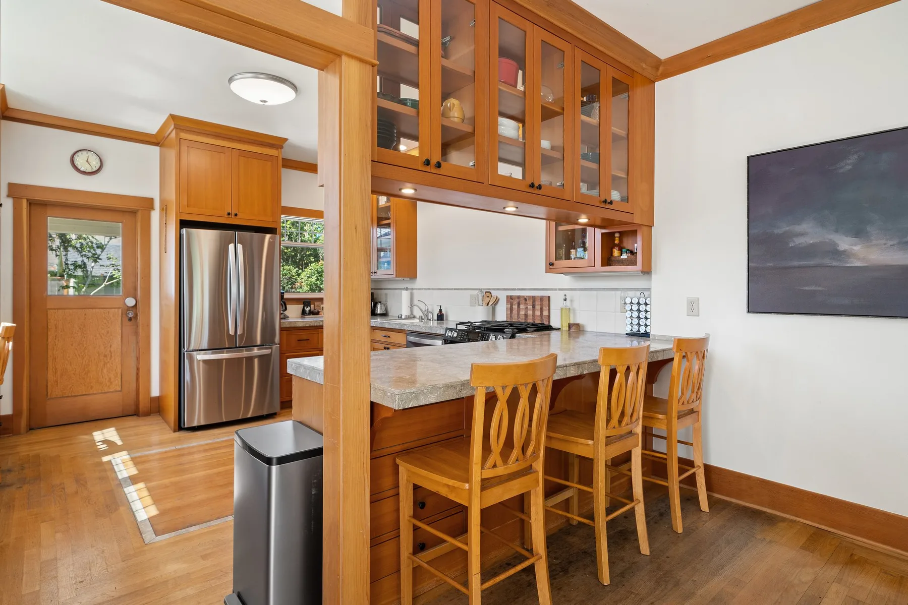 Una cocina con una isla de madera y varios taburetes.