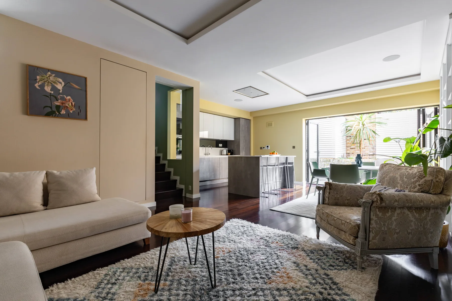 Una sala luminosa con asientos, una mesa de centro y una cocina abierta.
