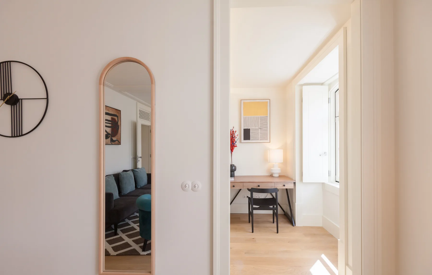 Un pasillo luminoso da a un rincón de comedor con una mesa junto a la ventana.