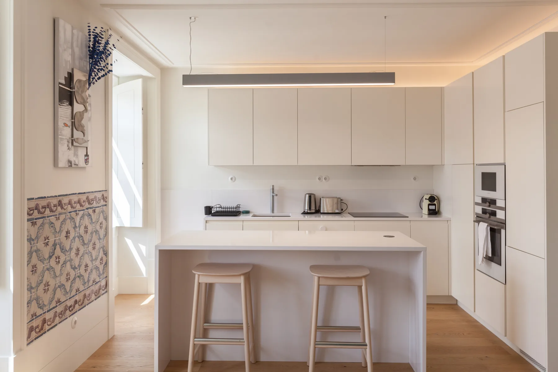 Una cocina moderna y luminosa con una isla y taburetes.