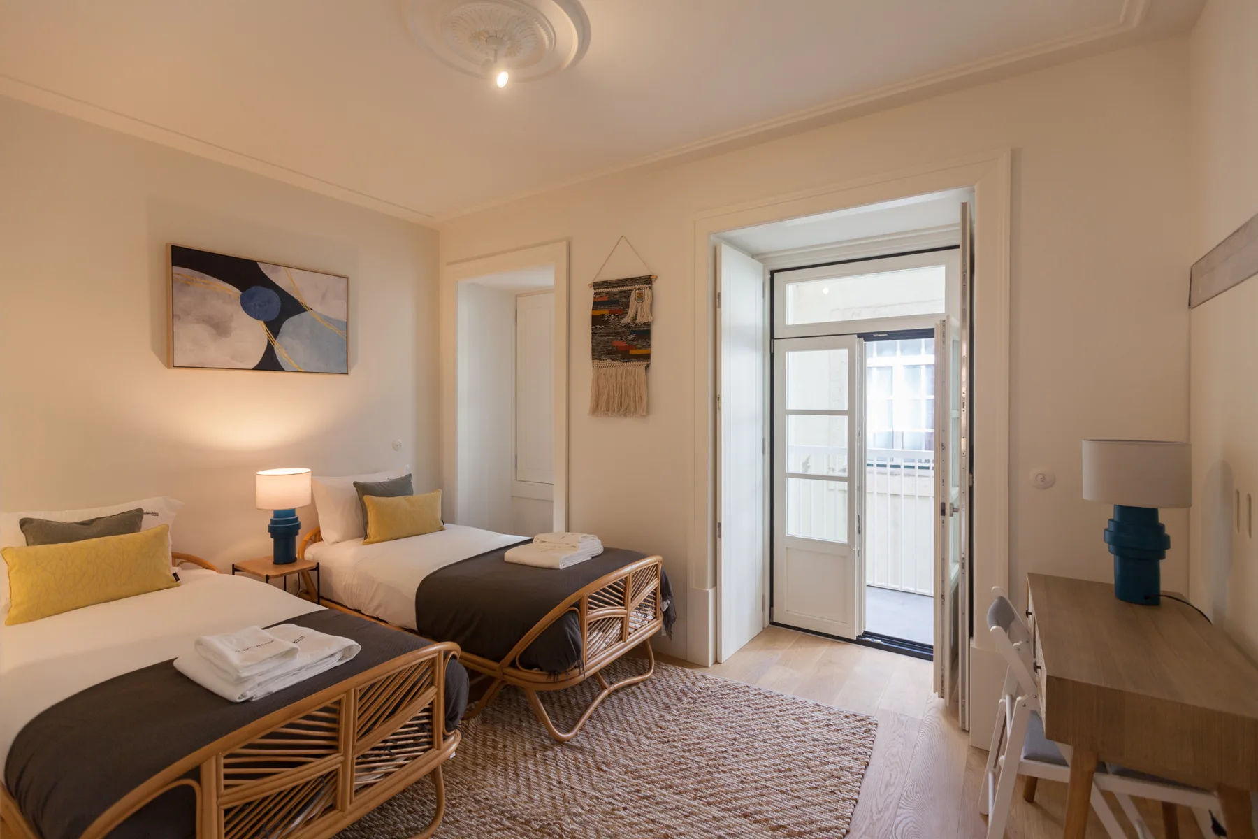 Un dormitorio con dos camas individuales y una puerta que da a un balcón.