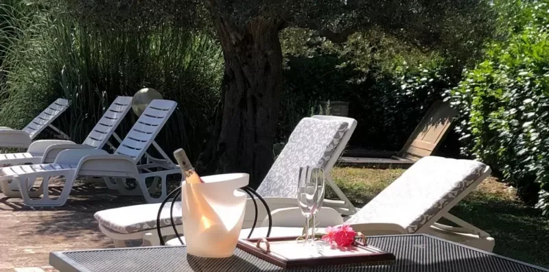 Outdoor patio with reclining lounge chairs and a small table.