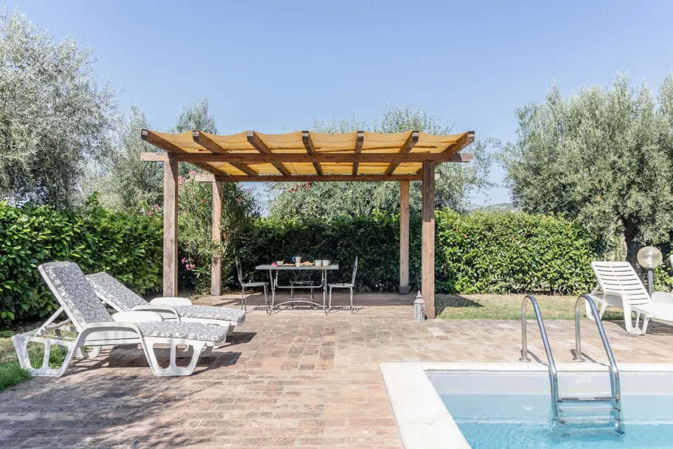 A poolside patio with lounge seating and a shaded dining area.