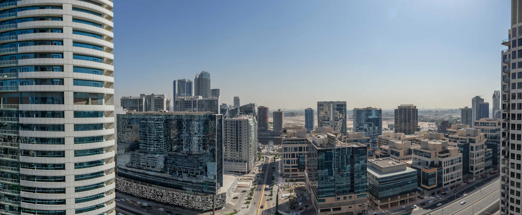 Un horizonte urbano con edificios modernos de gran altura bajo un cielo despejado.