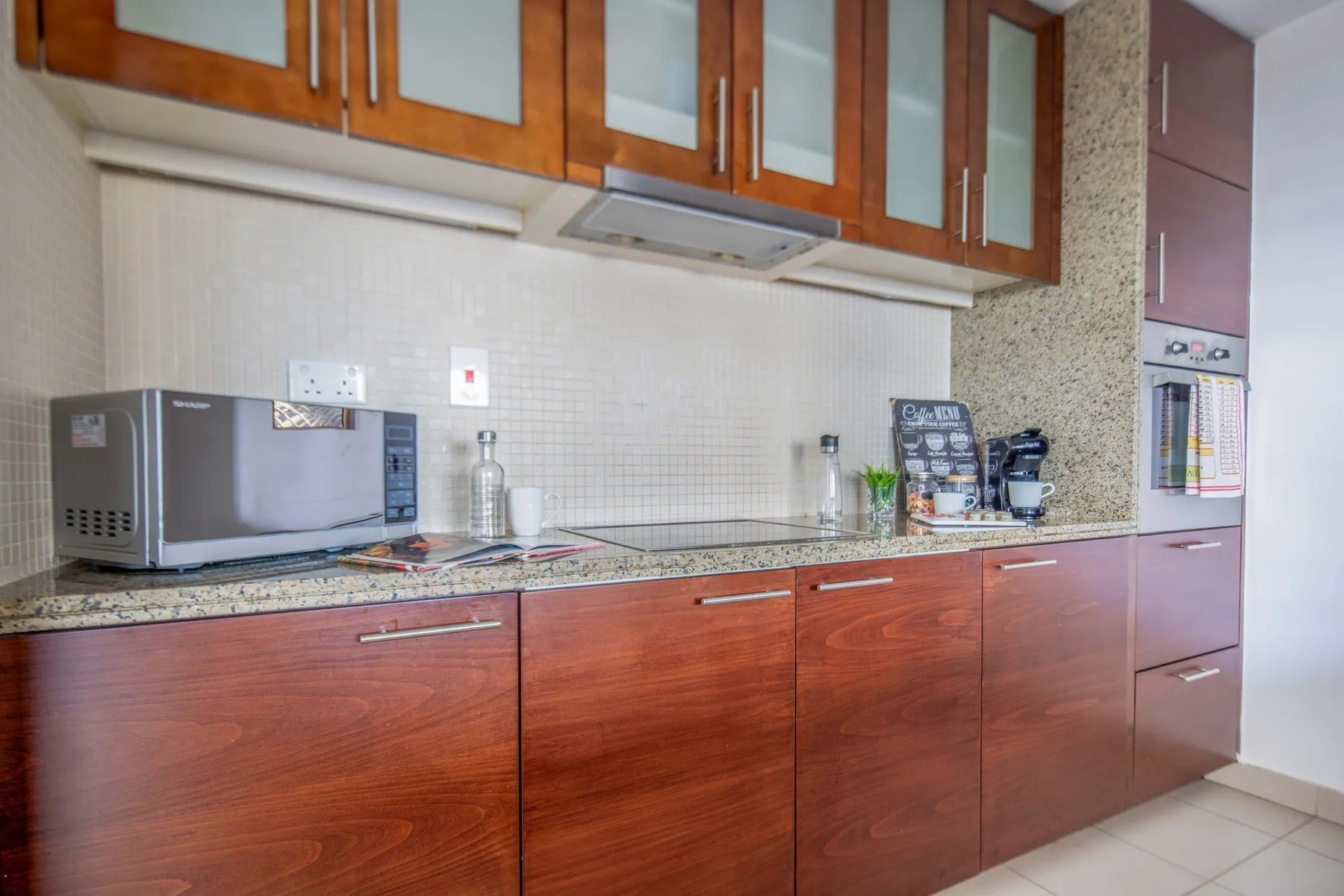 Una encimera de cocina con armarios de madera, un microondas y una estufa.