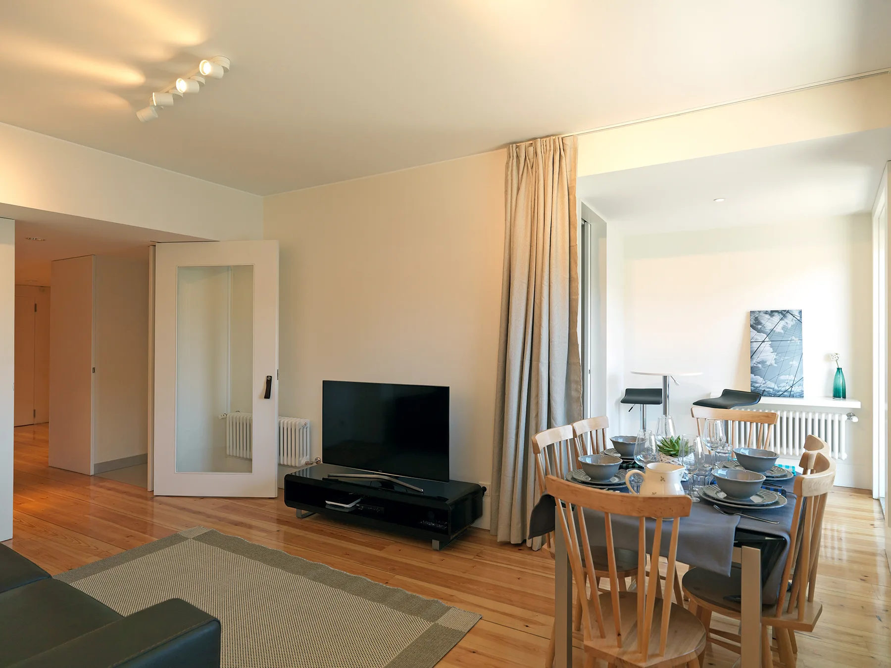 A living and dining area with a television, table, and chairs.