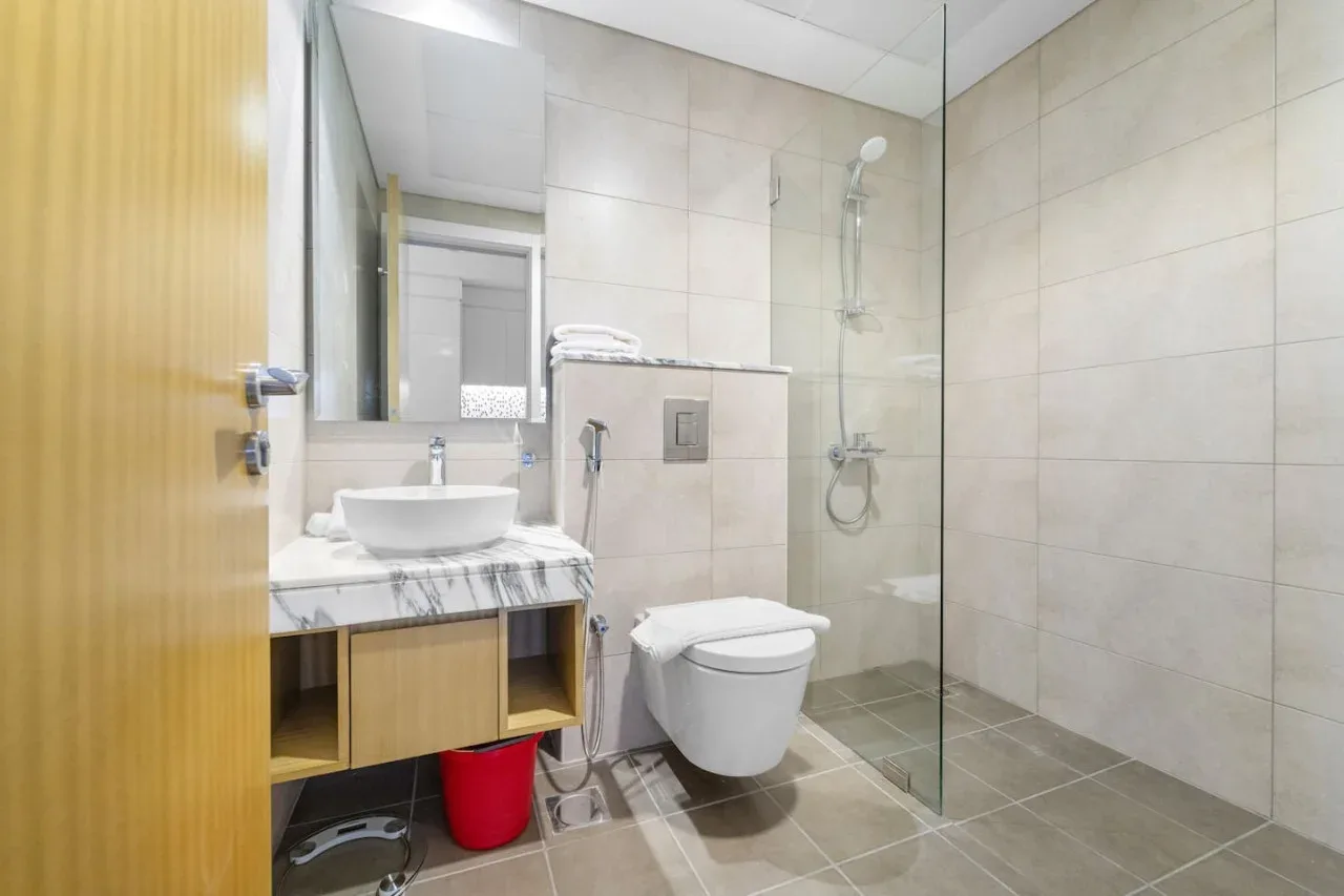 A tiled bathroom with a sink, toilet, and glass shower.