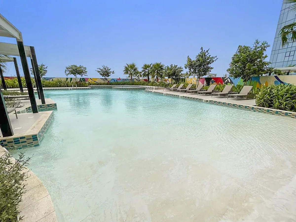 A swimming pool with lounge seating along its edge.