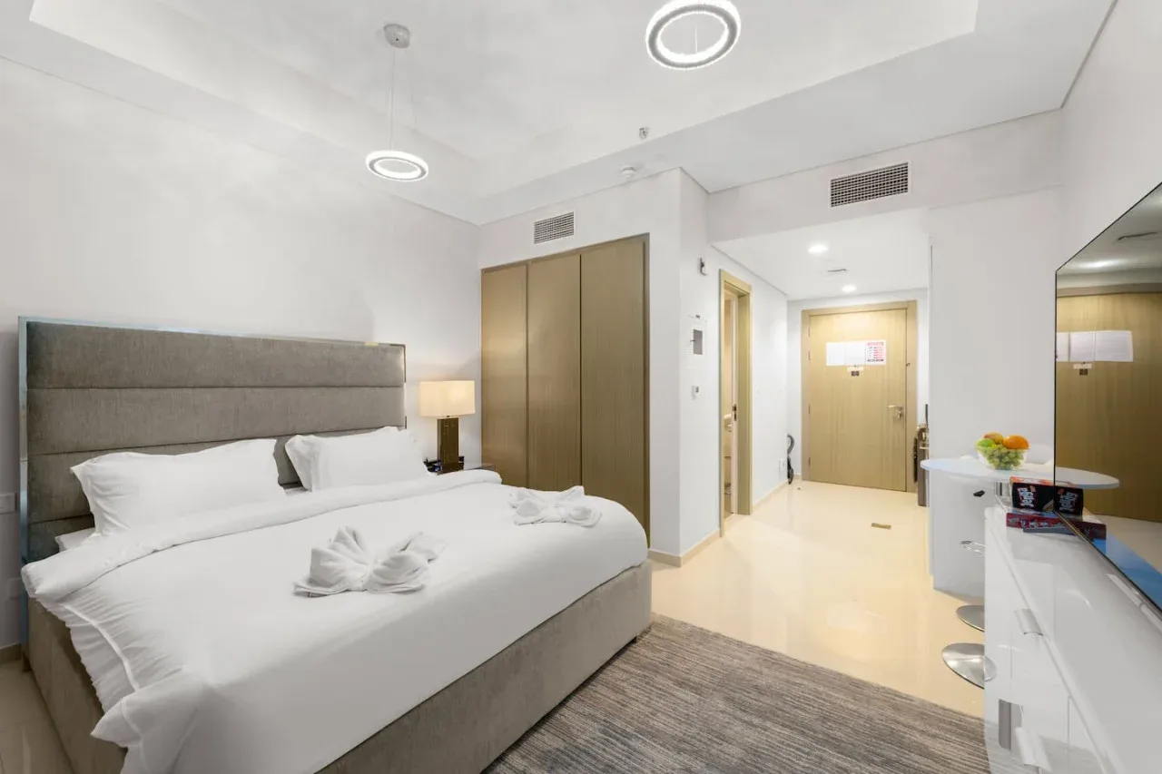 A bedroom with a large bed, wardrobe, and a desk area.