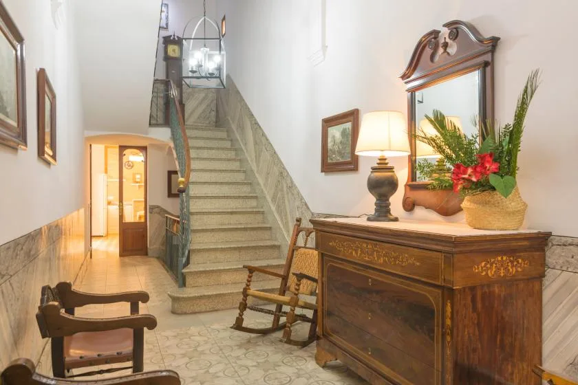 An interior hallway with a staircase and a wooden console table.