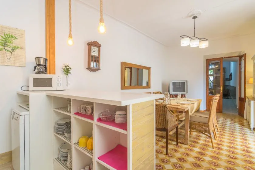 A dining area with a table and chairs beside an open kitchen counter.