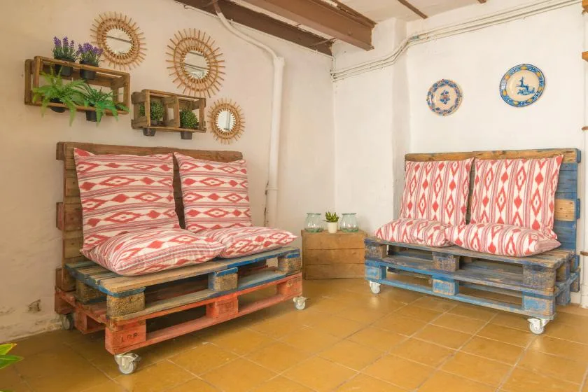 A rustic room with two pallet daybeds covered in patterned cushions.