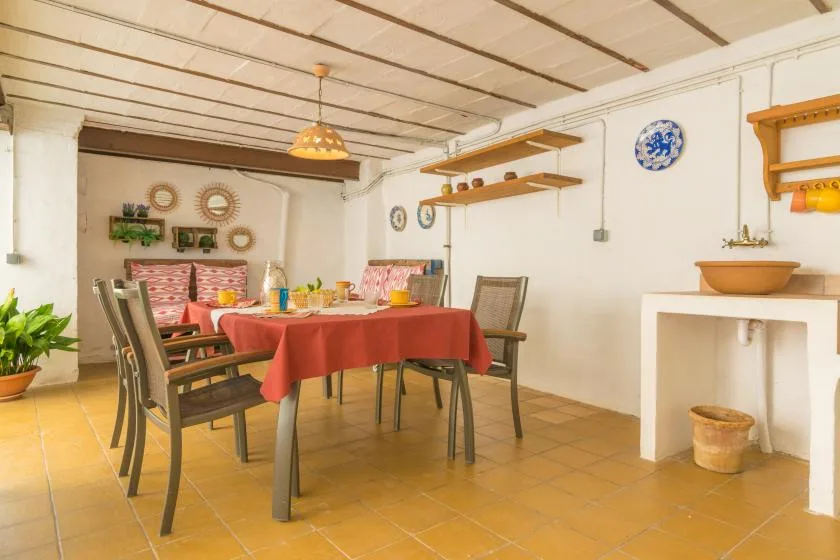 A dining room with a long table, chairs, and shelves along the walls.