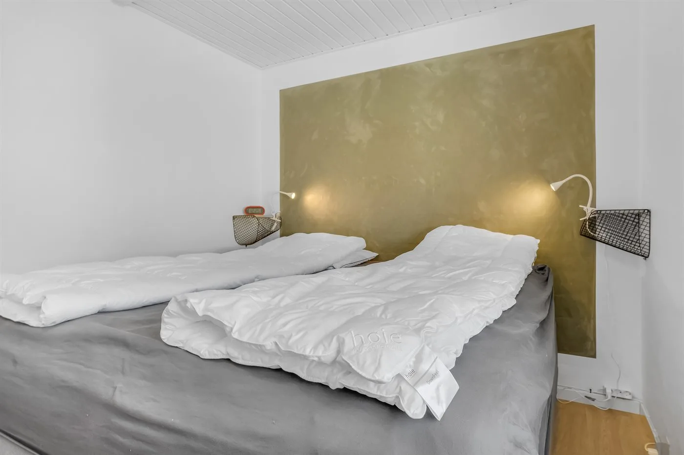 Dormitorio con camas cubiertas de ropa de cama blanca.