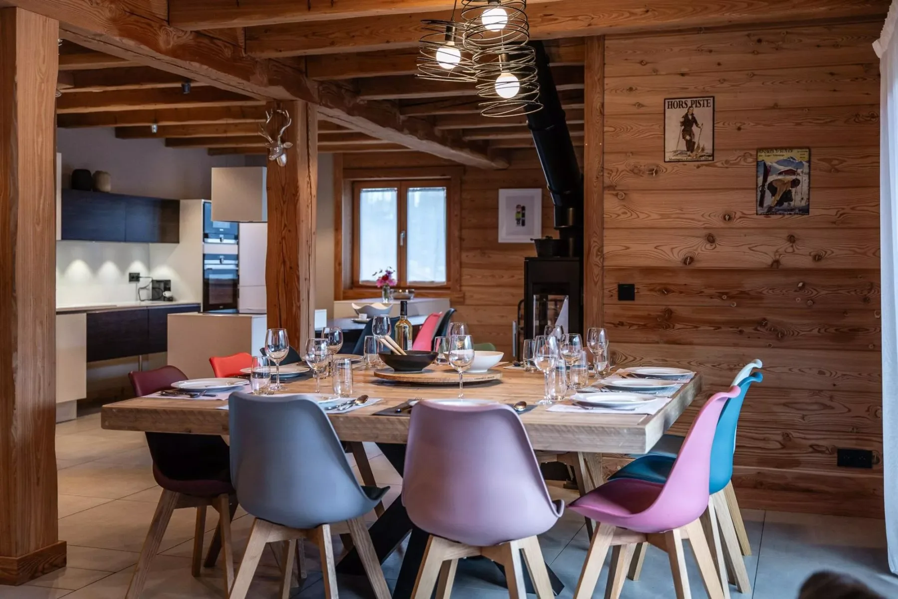A wood-paneled dining area with a set table and colorful seating.