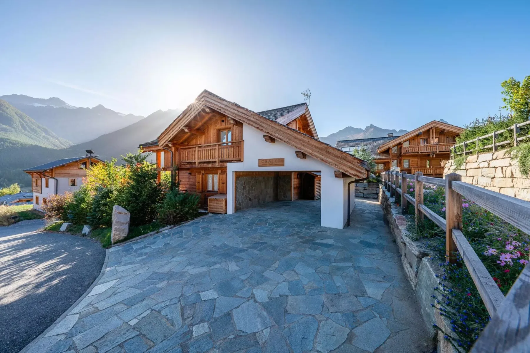 A mountain village scene with timber-and-white buildings beside a paved driveway.