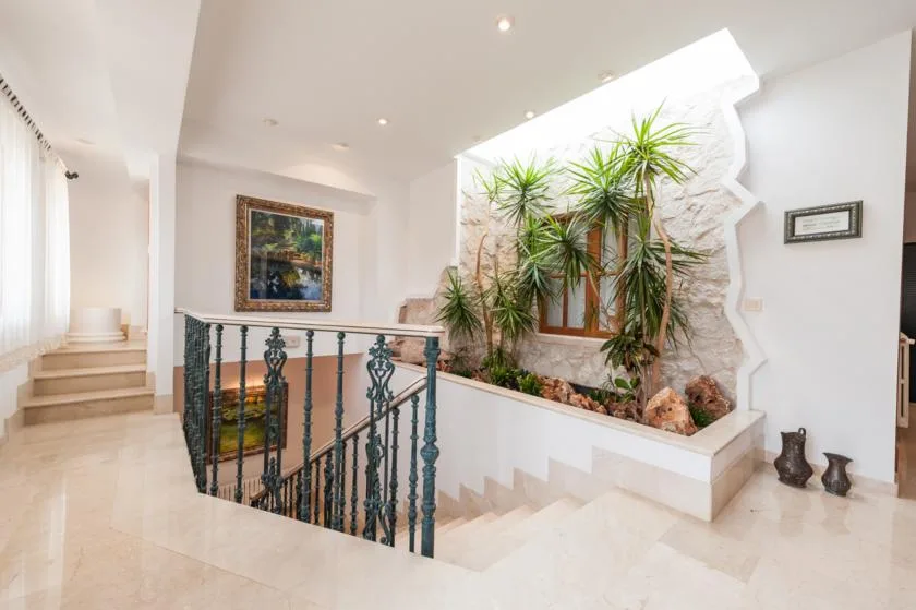 A bright interior stairwell with a decorative railing and a raised planter.