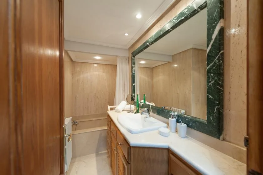 A bathroom vanity with a wide sink and a large framed mirror.