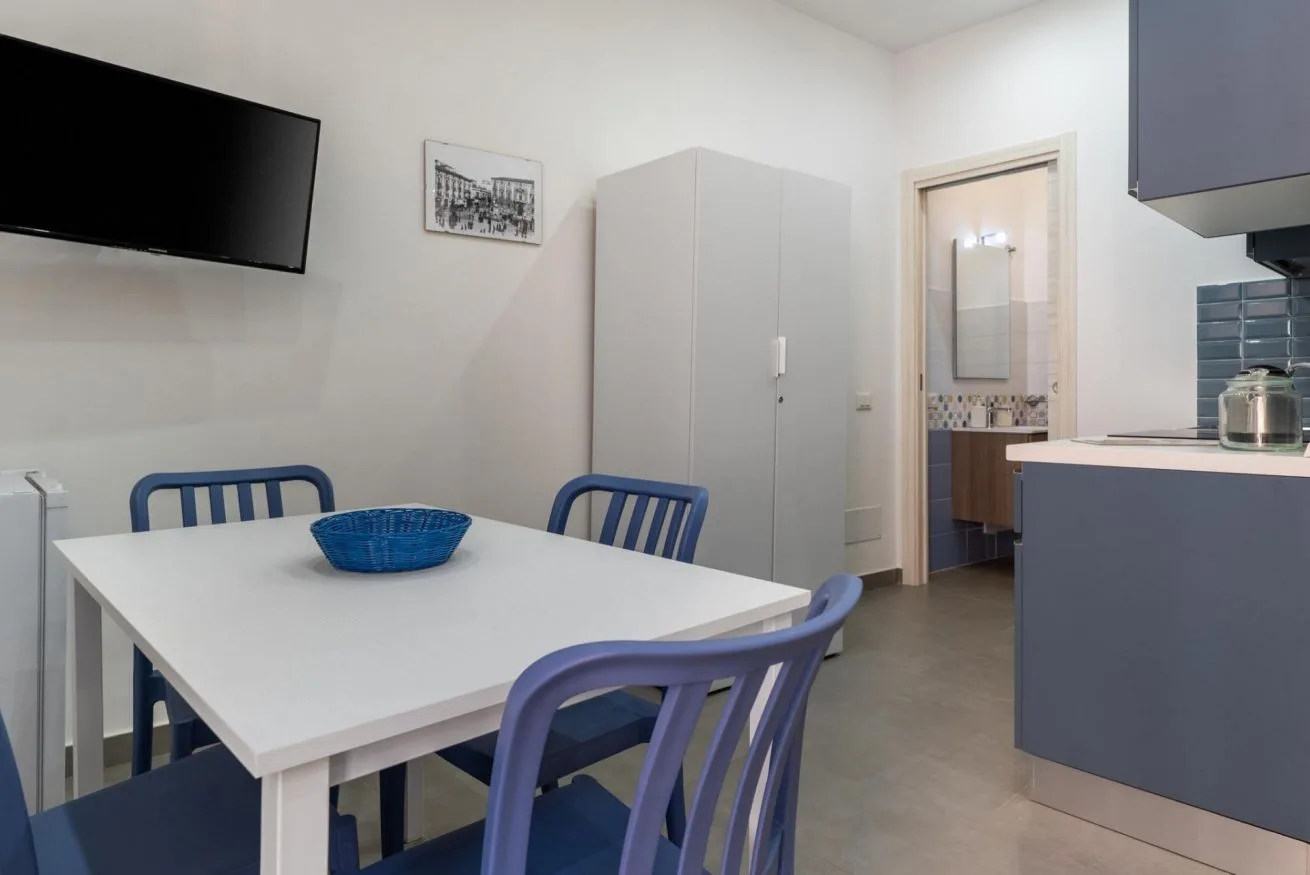 A dining area with a white table and blue seating.