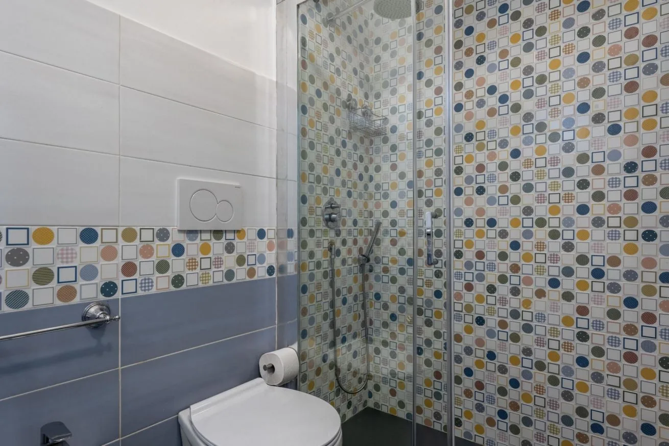 A tiled bathroom with a shower and toilet.
