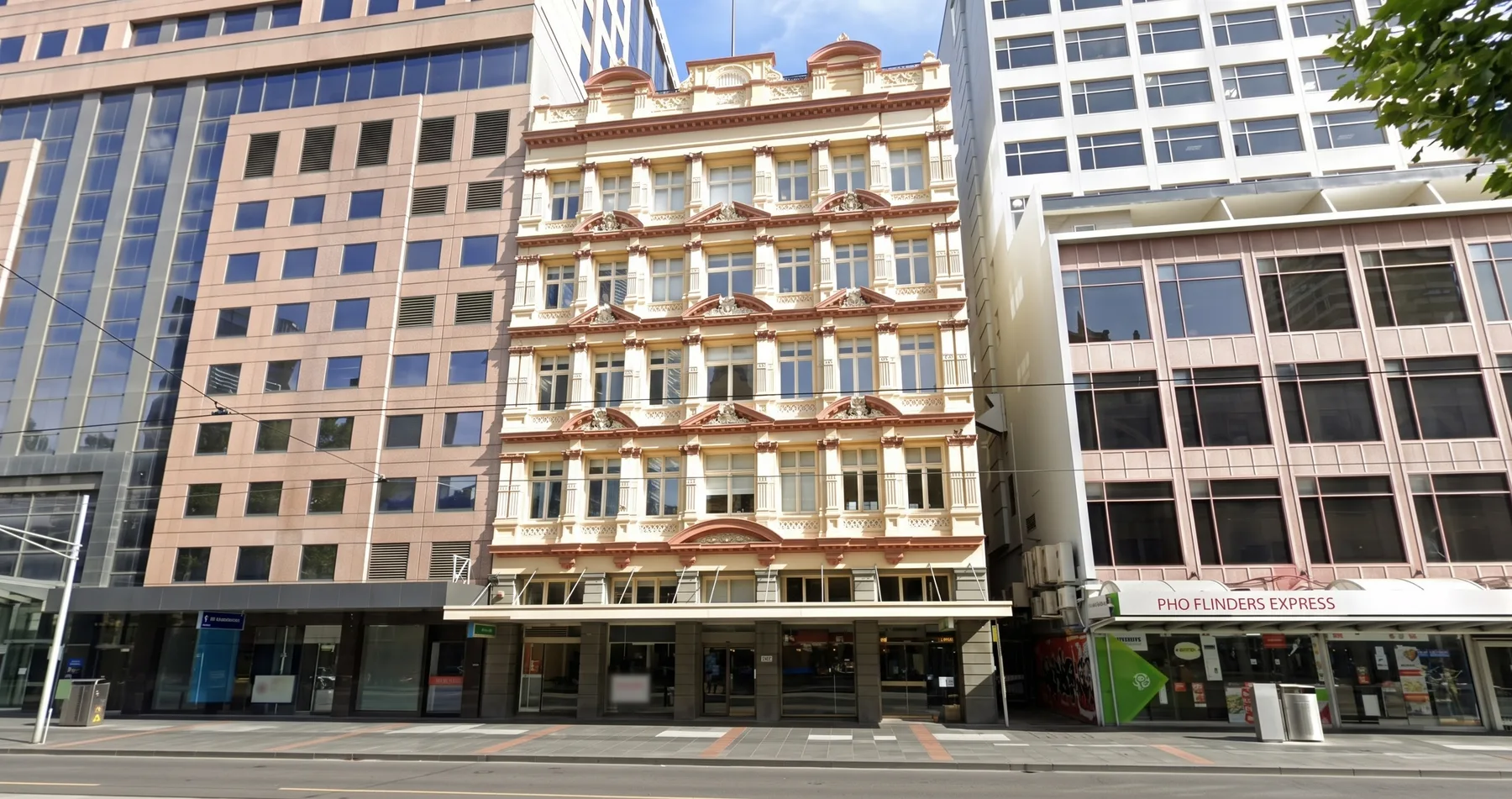 A city street lined with tall office buildings and storefronts.