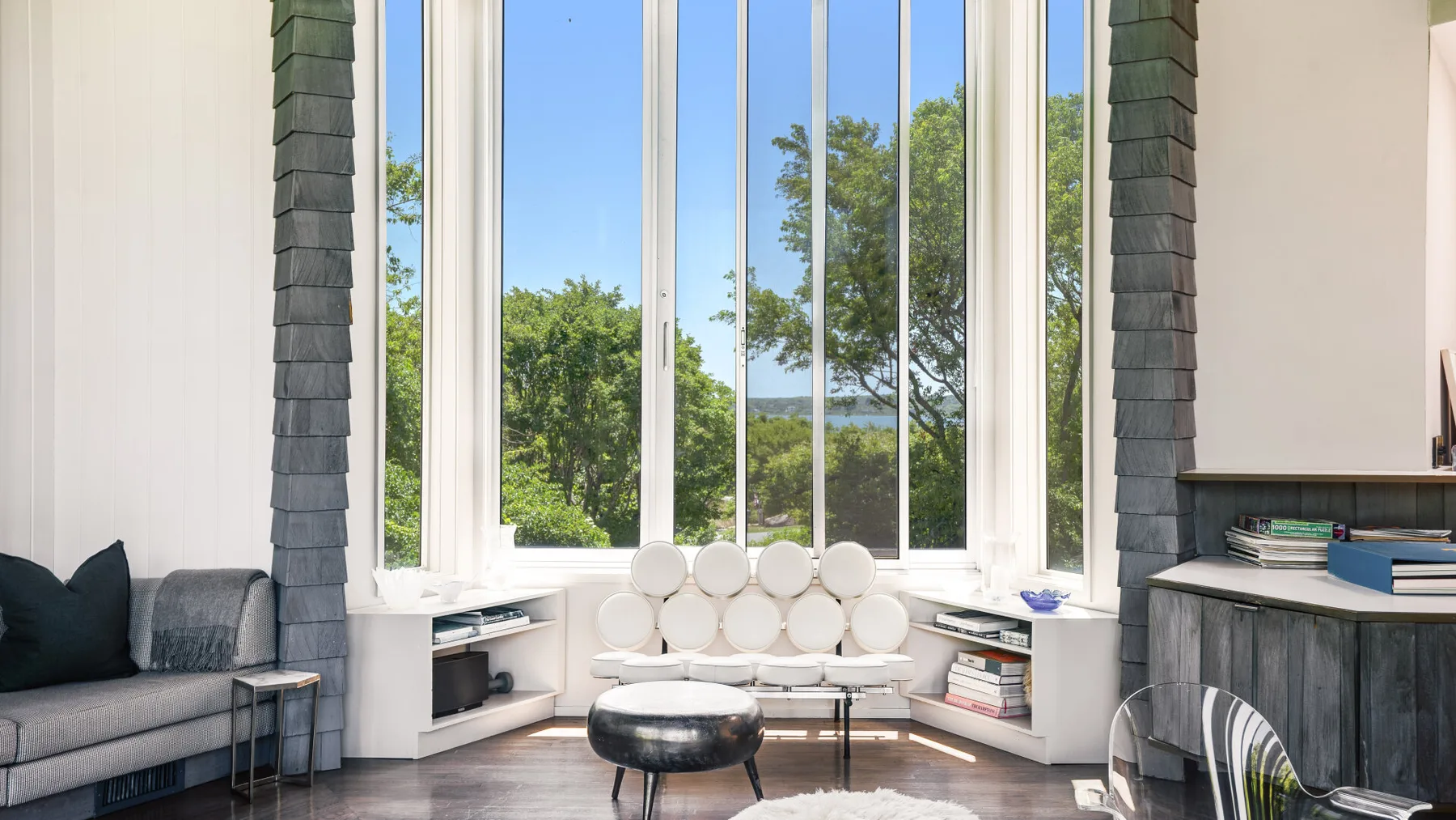 A bright living room with seating arranged in front of large windows.