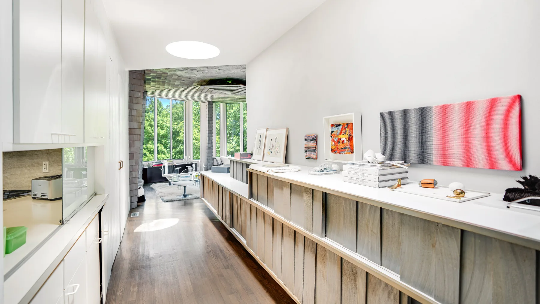 A bright gallery-like room with a long counter and large windows at the far end.