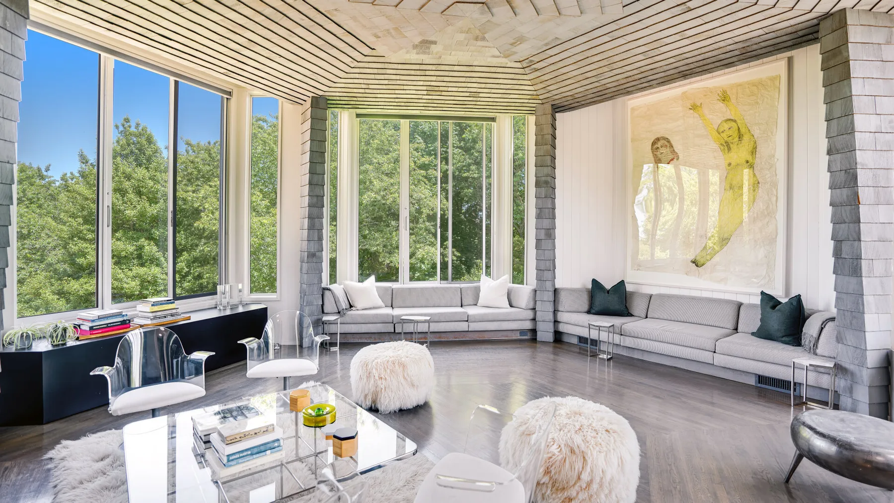 A bright living room with large windows and light-colored seating.