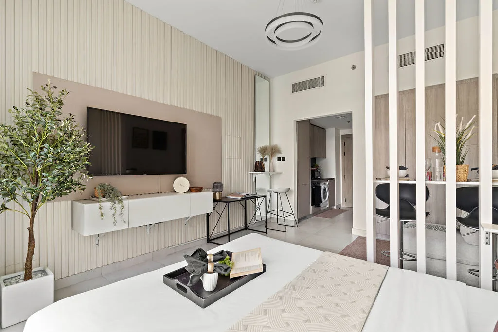 Una luminosa sala de estar moderna con televisor en la pared y mesa de comedor.