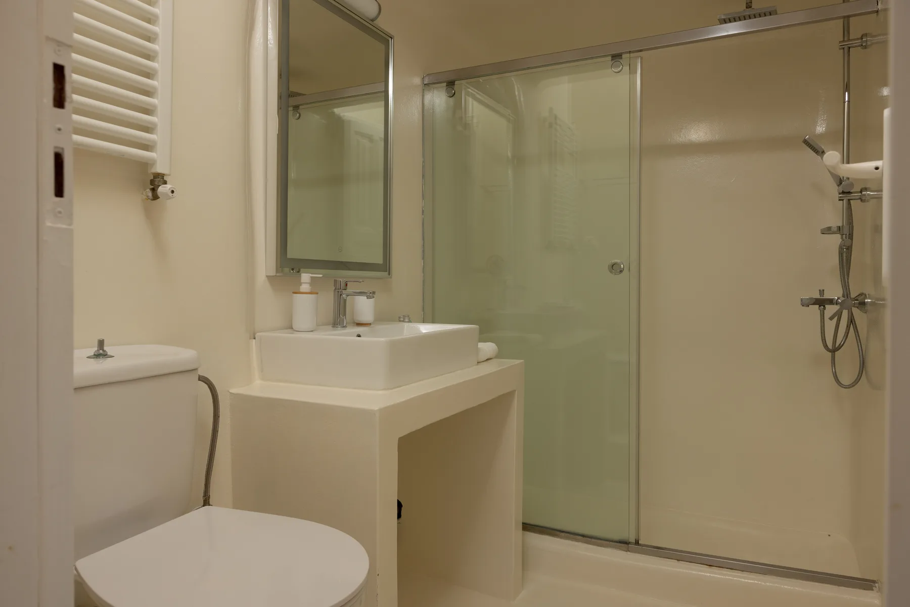 A bathroom with a sink, toilet, and glass shower.