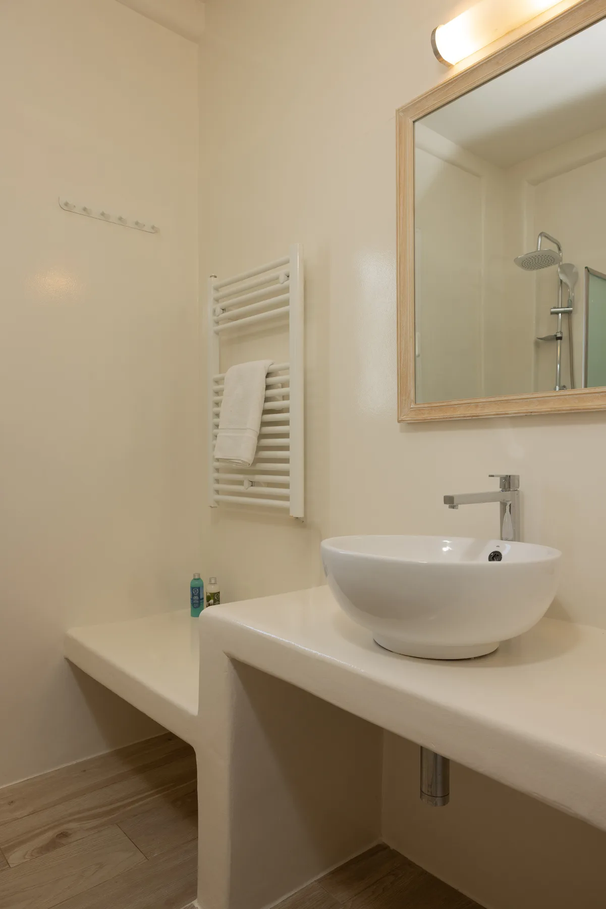 A bathroom vanity with a basin and a towel warmer.