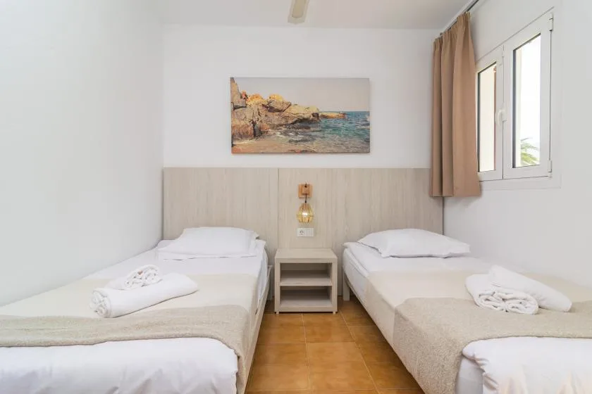 A twin bedroom with two beds and a small bedside table.