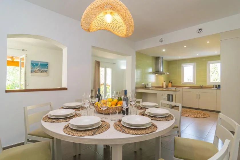 A dining area with a round table set beside an open kitchen.