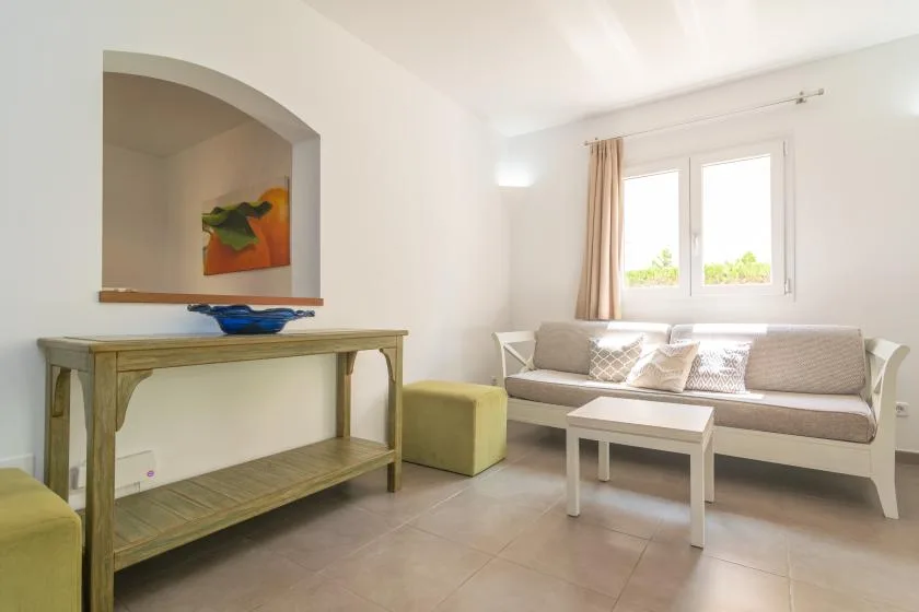 A bright living room with a sofa beneath a window and a low coffee table.