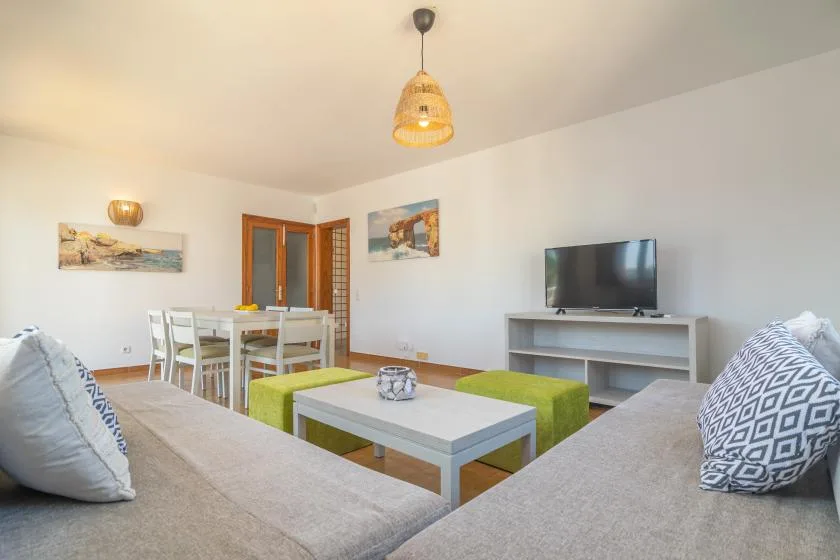 A living room with seating arranged around a low coffee table and television.