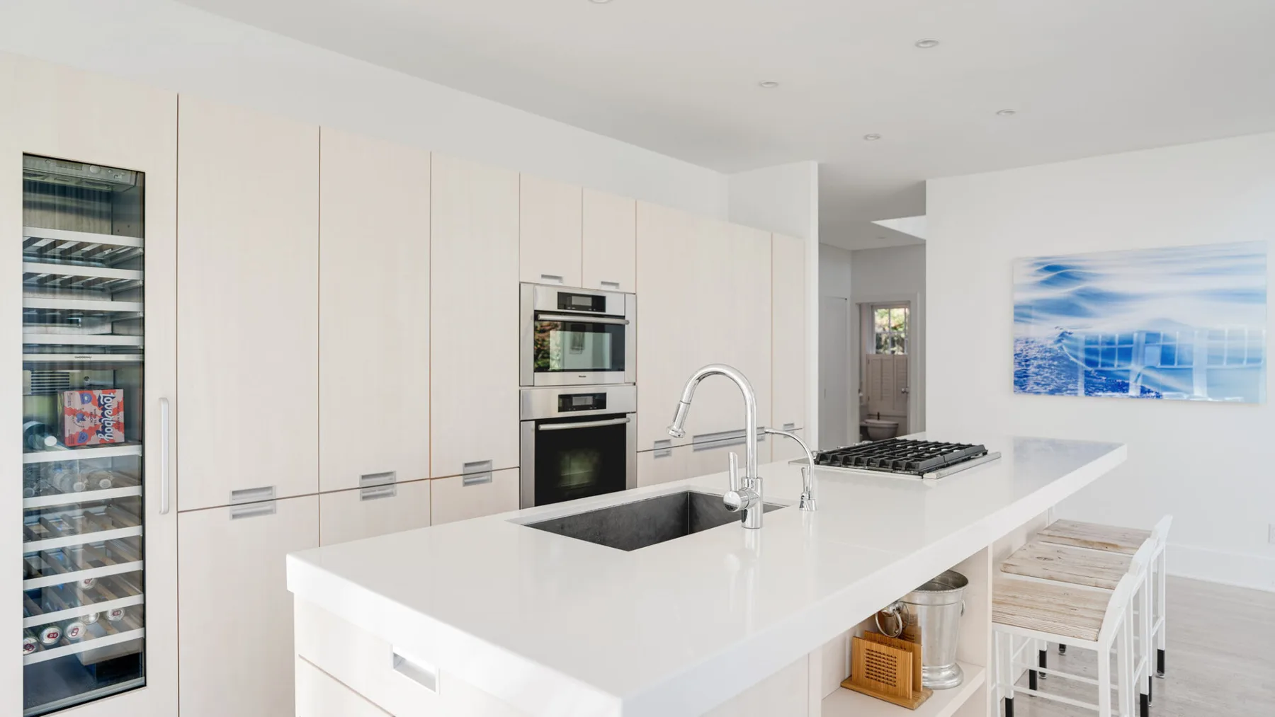 Una cocina moderna y luminosa con una isla grande y electrodomésticos integrados.