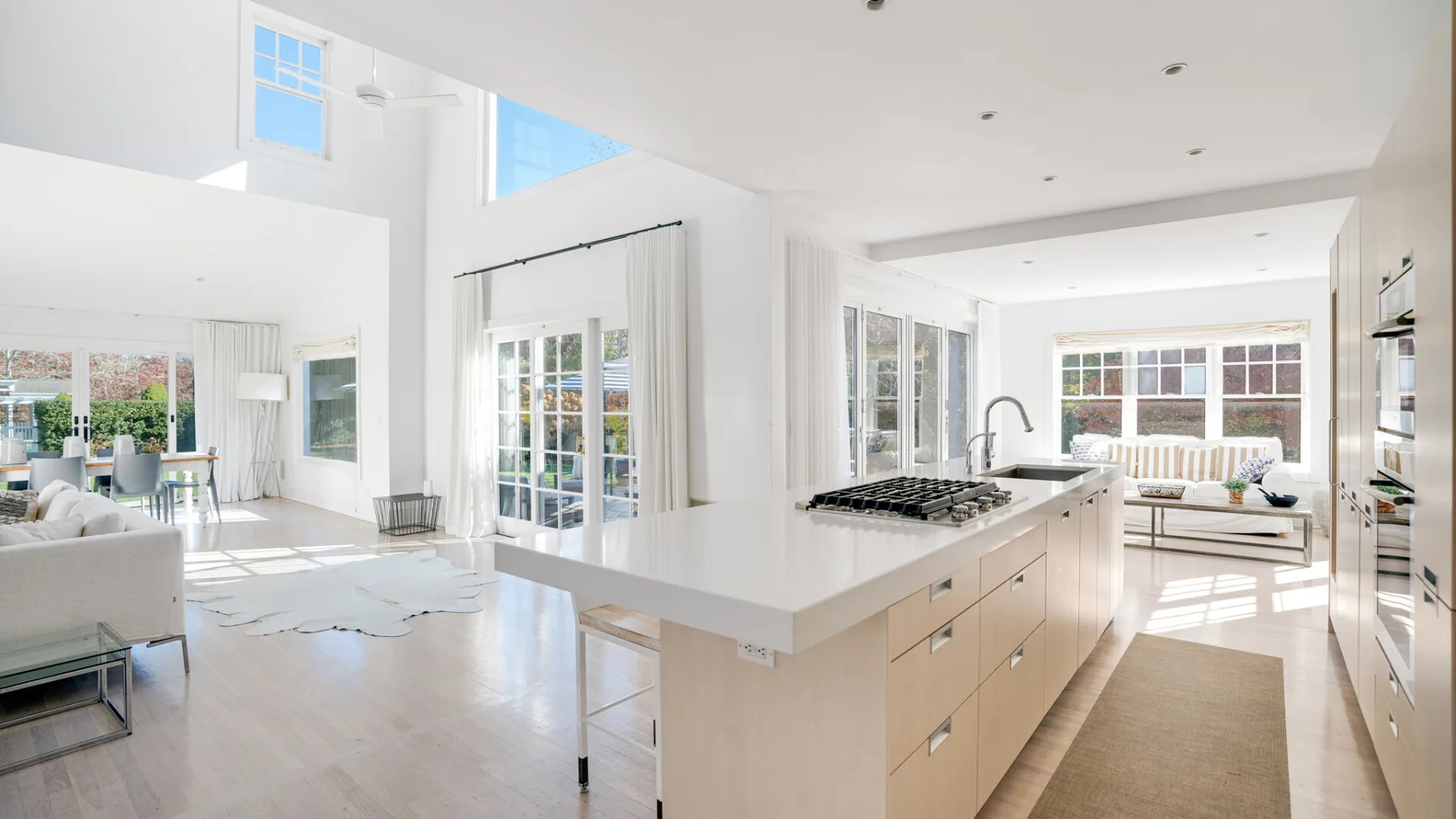 Una luminosa cocina y sala de estar de planta abierta con una gran isla central.