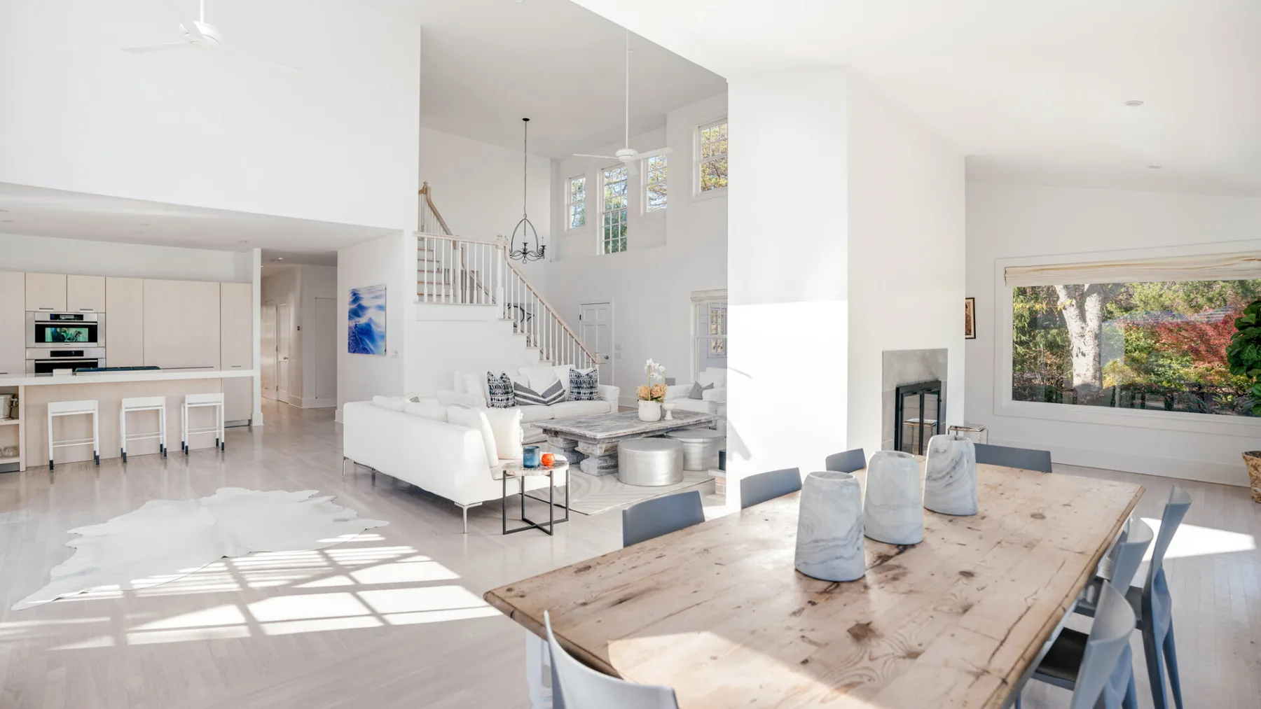 Una luminosa sala de estar y comedor de concepto abierto con una larga mesa de madera.
