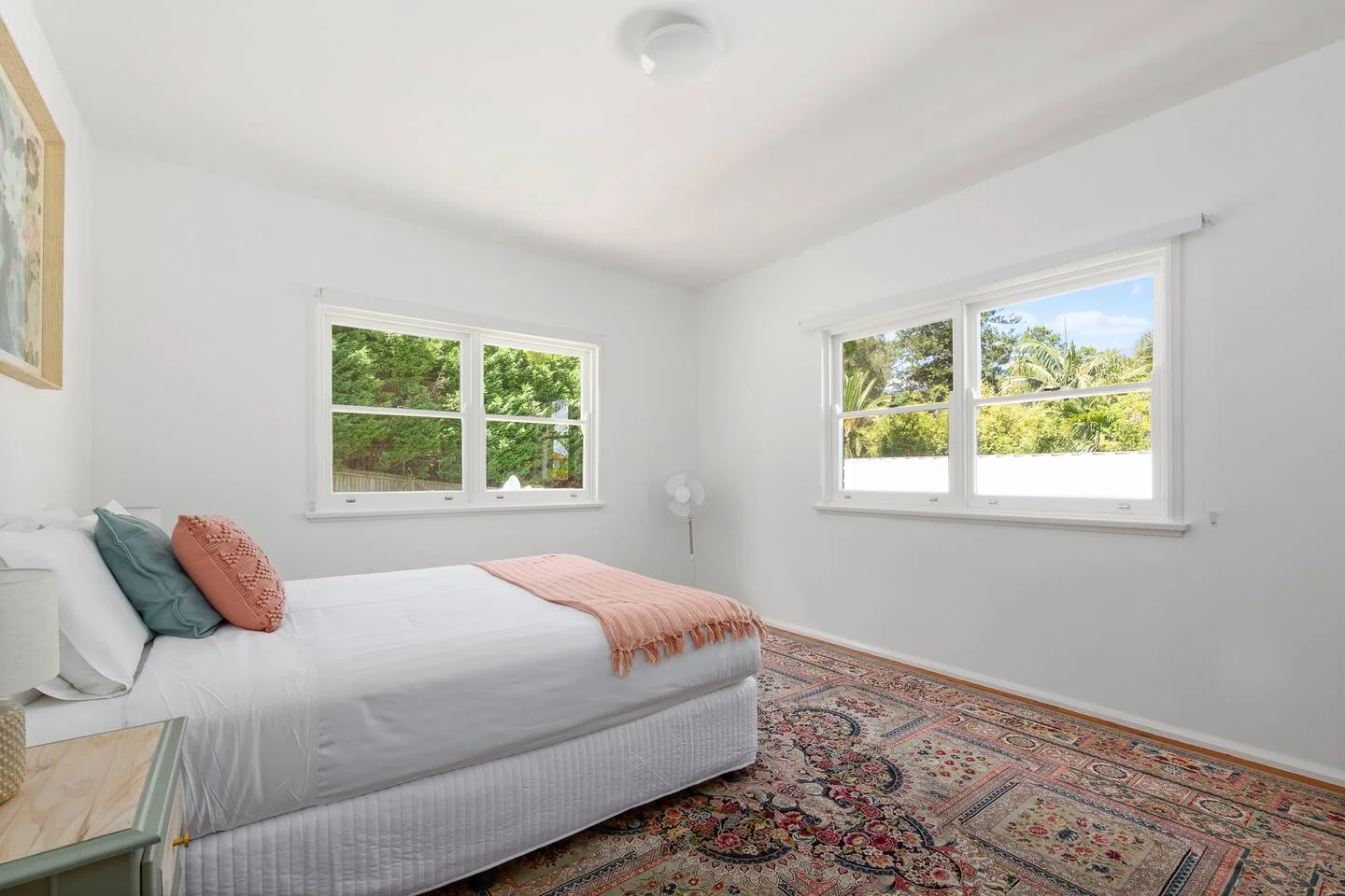 The primary bedroom offers a queen bed, soft natural light and simple, calming décor for a restful night’s sleep.