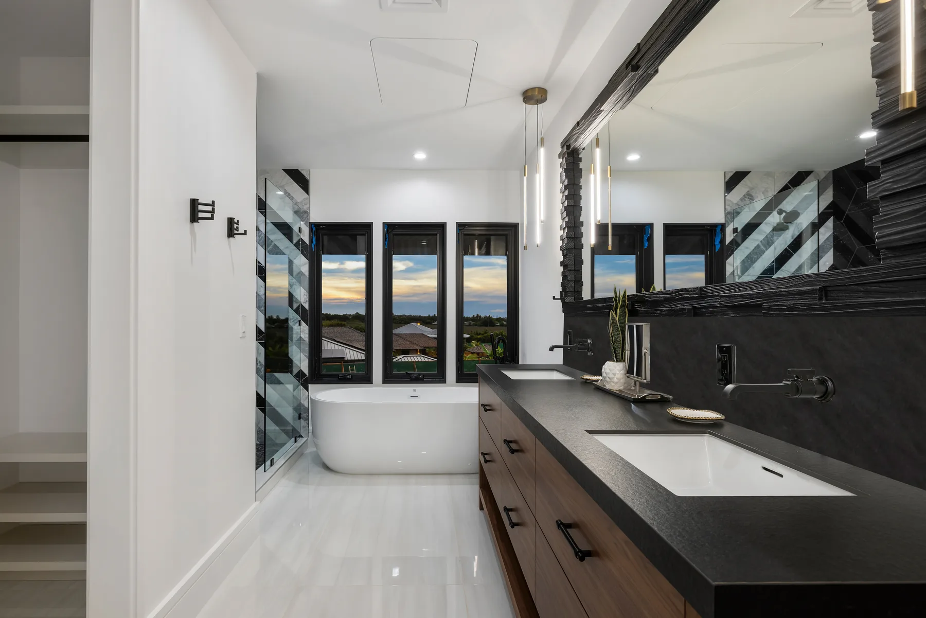 Un baño moderno con bañera, lavabo y grandes ventanas.