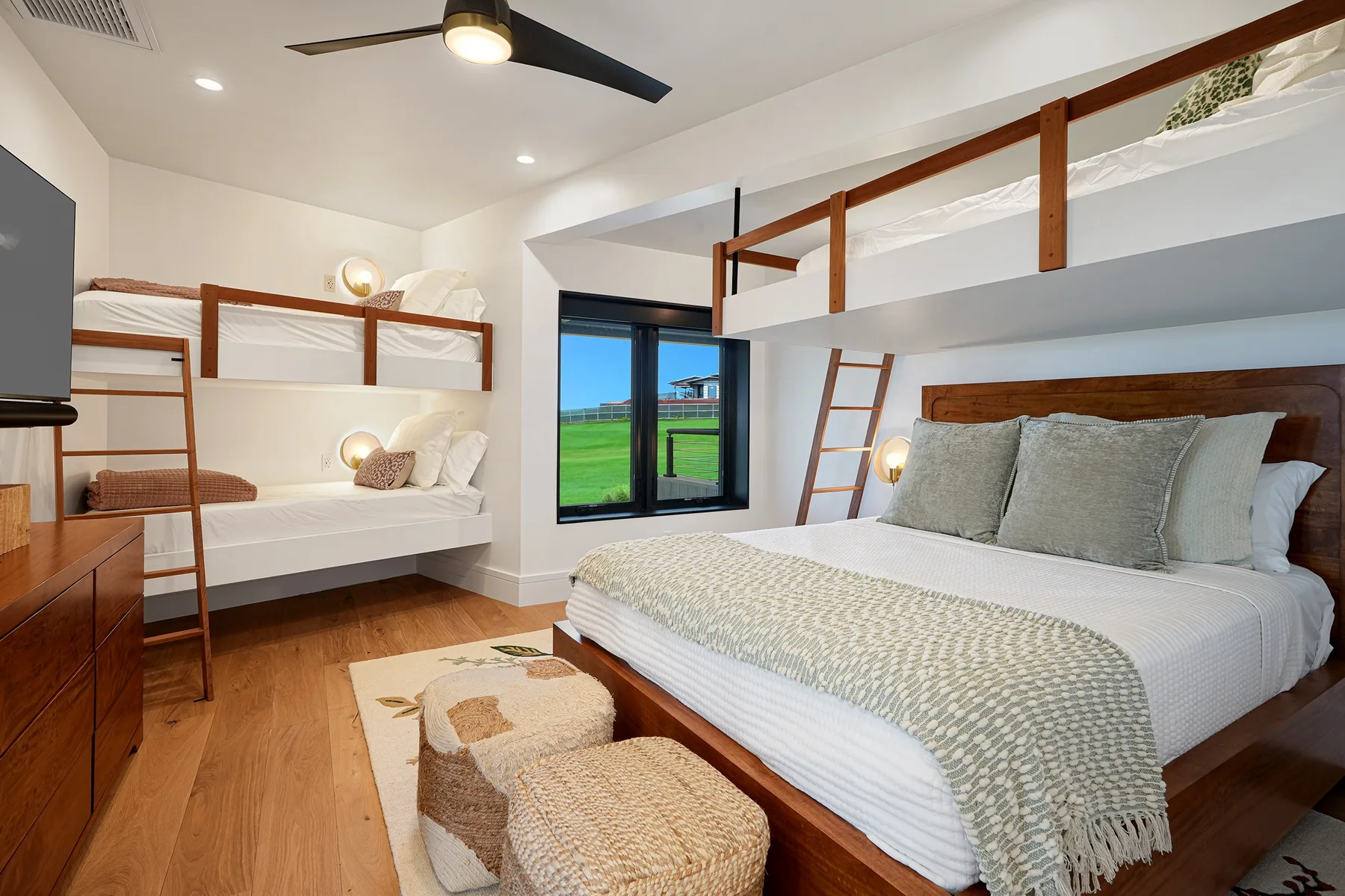 Un dormitorio con una cama grande y literas integradas.
