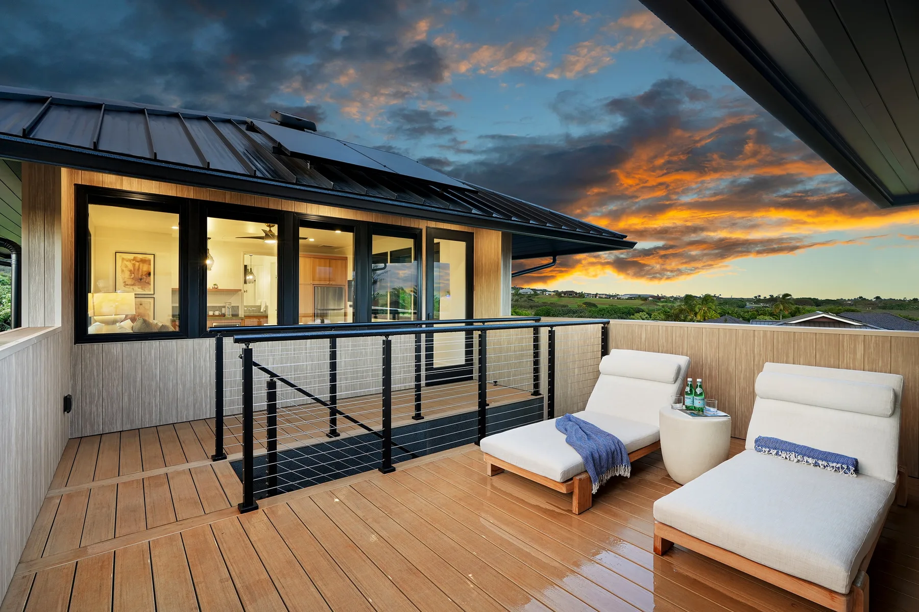 Una terraza en la azotea con asientos al aire libre da a un paisaje al atardecer.