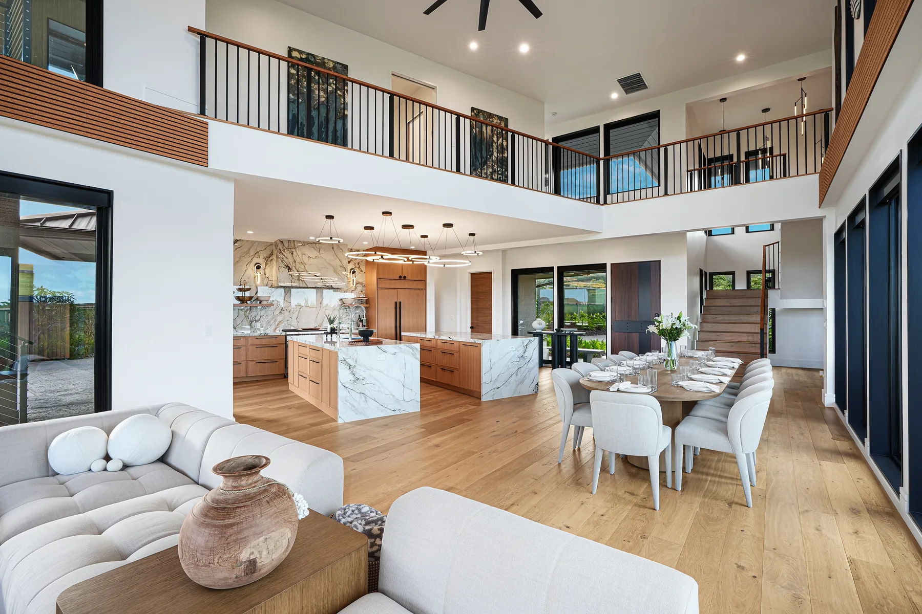 Una zona diáfana de salón, comedor y cocina con un balcón en la planta superior.