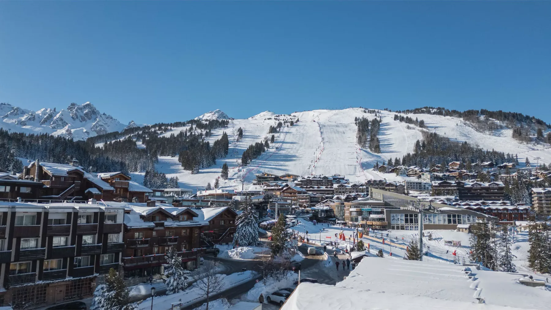 A snowy mountain ski resort with ski slopes and buildings.