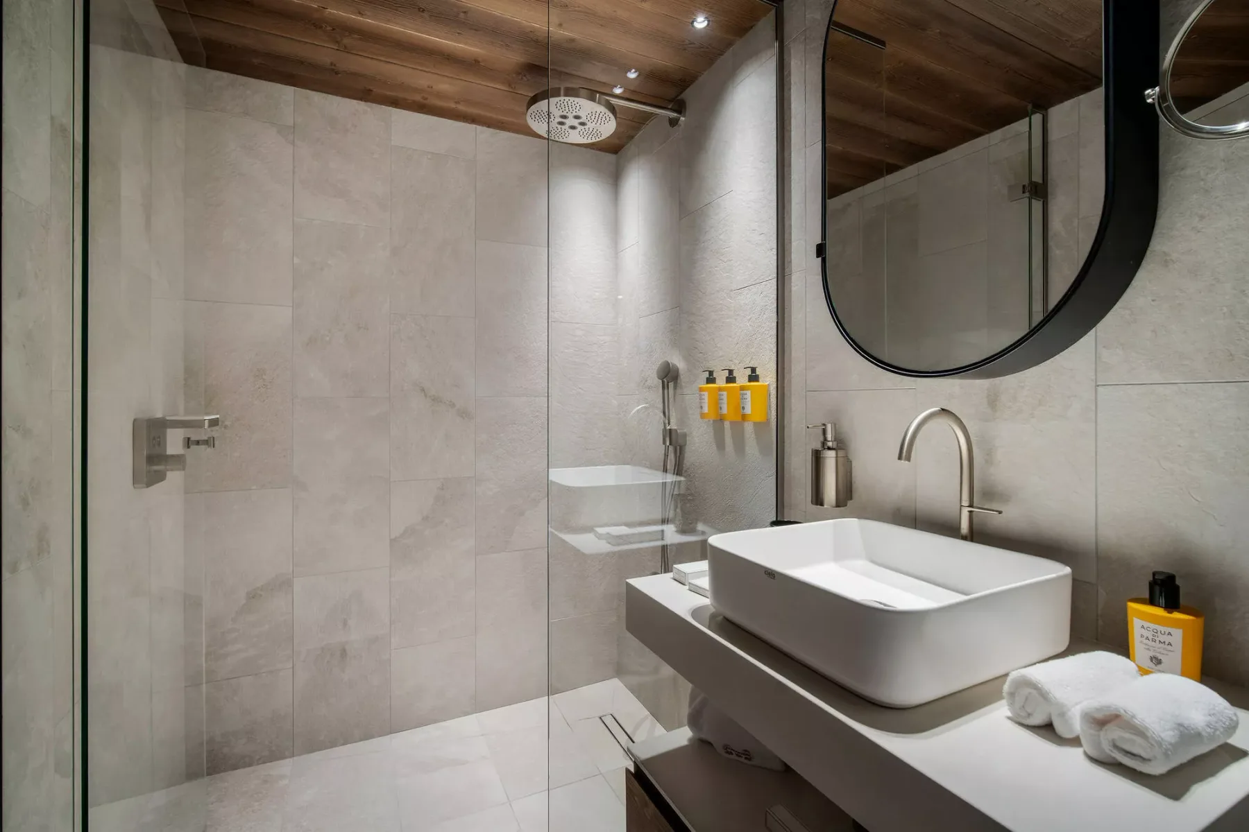 A bathroom with a sink, large mirror, and walk-in shower.