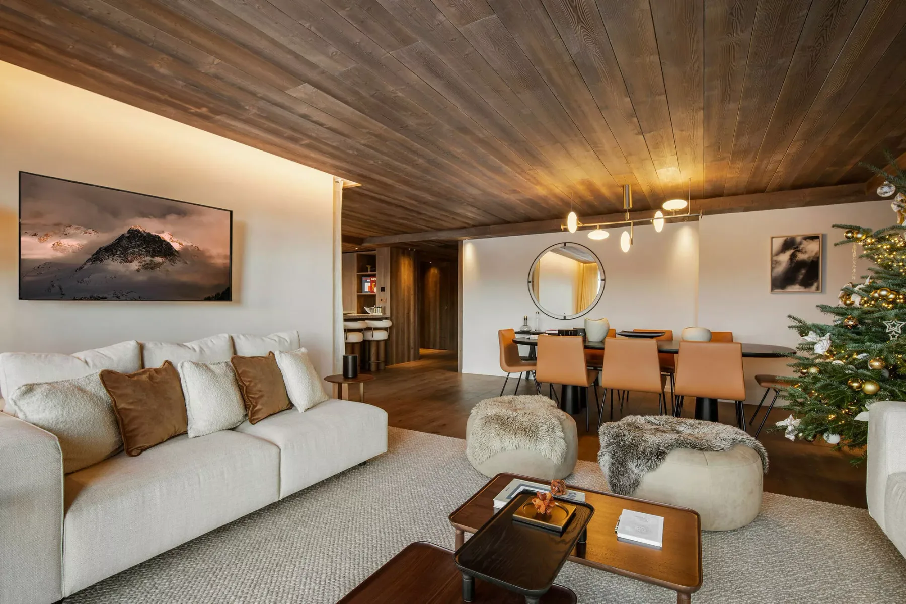A living and dining area with seating, a coffee table, and a decorated tree.
