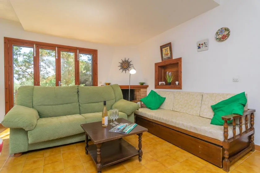 A living room with green and cream seating around a low coffee table.