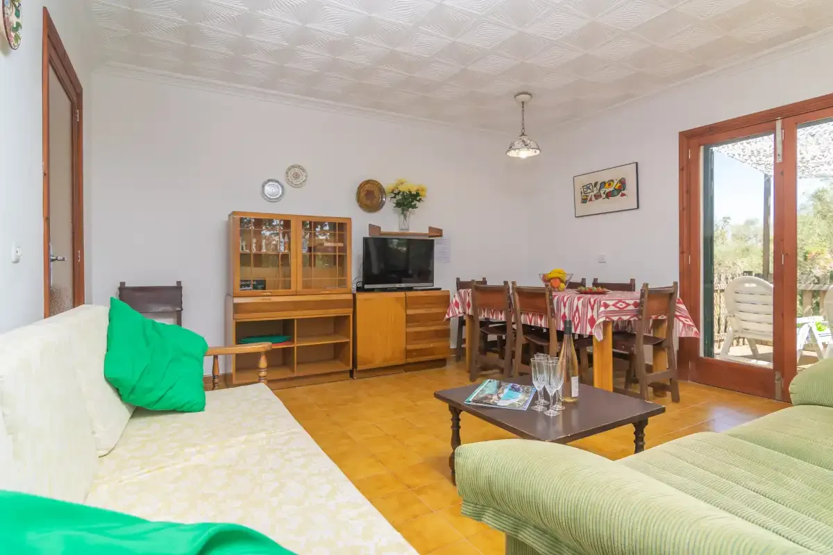 A living and dining room with seating, a television, and a table.