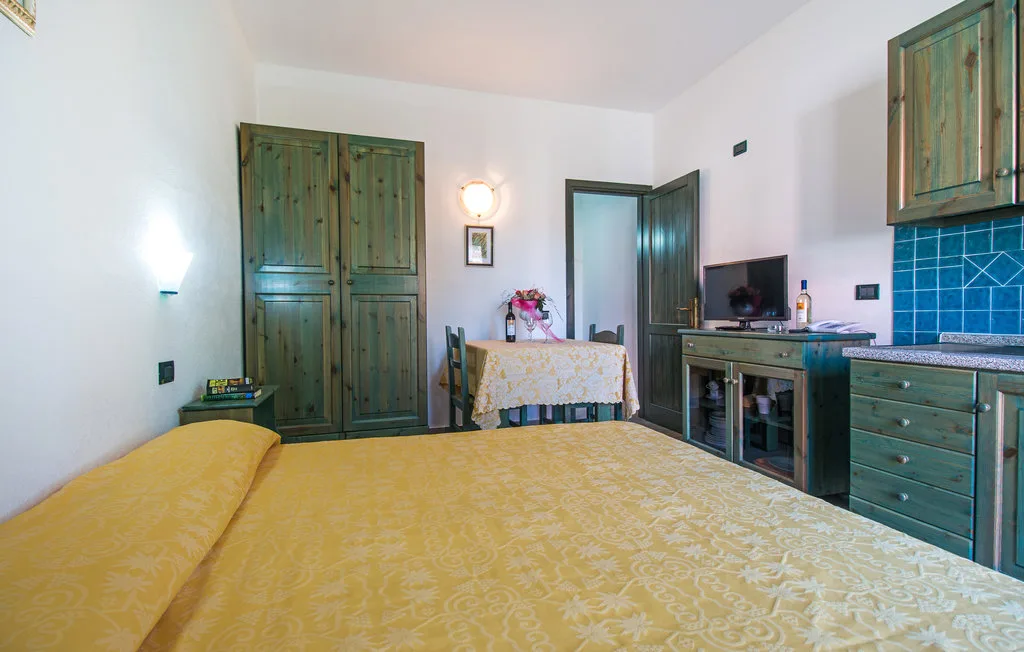 Un dormitorio con una cama grande, armarios de madera y un escritorio junto a la puerta.